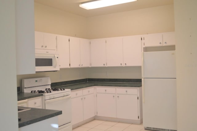 1922 Sassafras Dr, Wesley Chapel, FL 33543 - kitchen featuring white appliances, dark countertops, and white cabinetry