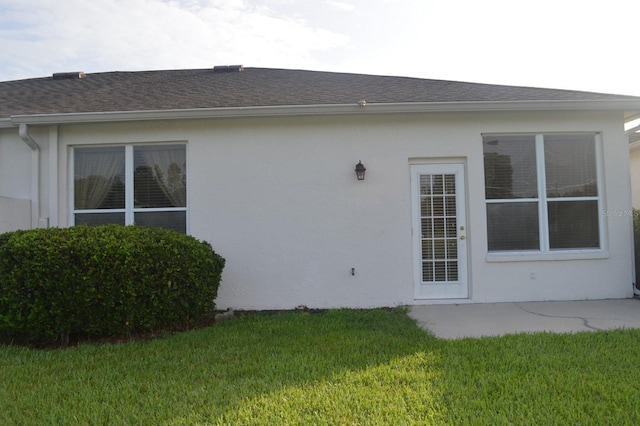 1922 Sassafras Dr, Wesley Chapel, FL 33543 - rear view of house with stucco siding, a yard, and roof with shingles