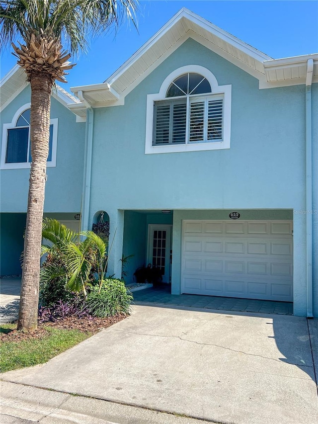 659 Garland Cir, Indian Rocks Beach, FL 33785 - view of front of home with an attached garage, stucco siding, and driveway