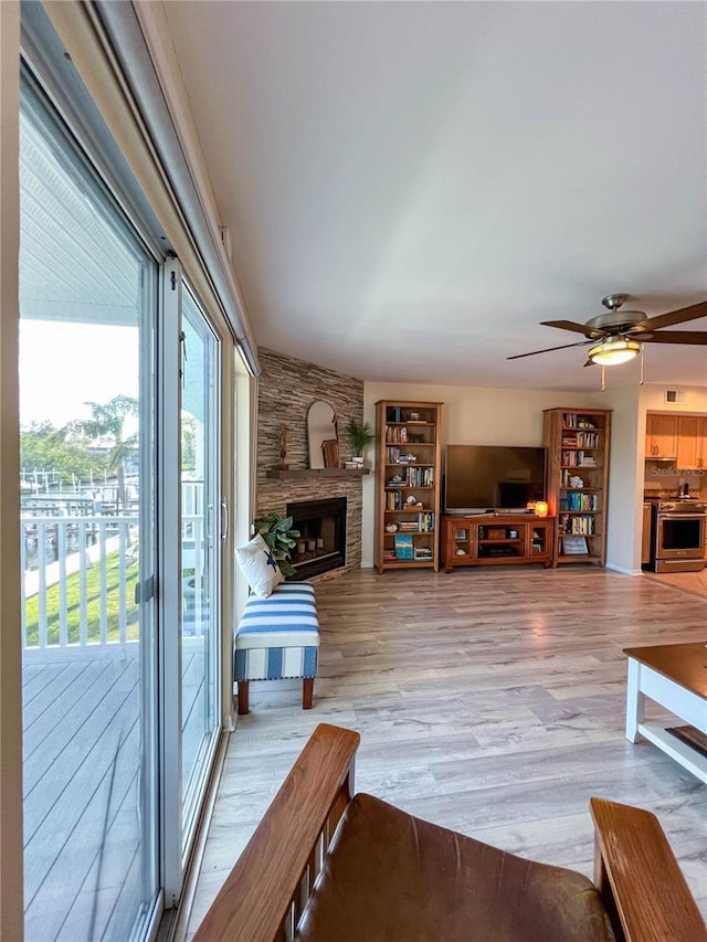 659 Garland Cir, Indian Rocks Beach, FL 33785 - living area featuring light wood-style flooring, healthy amount of natural light, a large fireplace, and ceiling fan