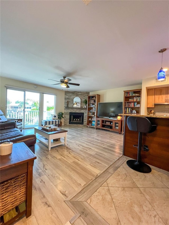 659 Garland Cir, Indian Rocks Beach, FL 33785 - living room with a fireplace, ceiling fan, and light wood-style floors