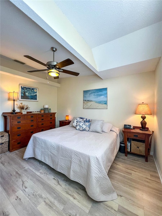 659 Garland Cir, Indian Rocks Beach, FL 33785 - bedroom with light wood-type flooring, vaulted ceiling, ceiling fan, and baseboards