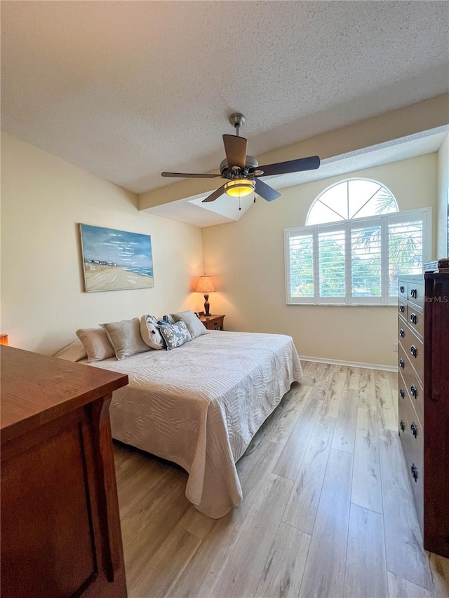 659 Garland Cir, Indian Rocks Beach, FL 33785 - bedroom featuring light wood-style floors, a textured ceiling, and a ceiling fan
