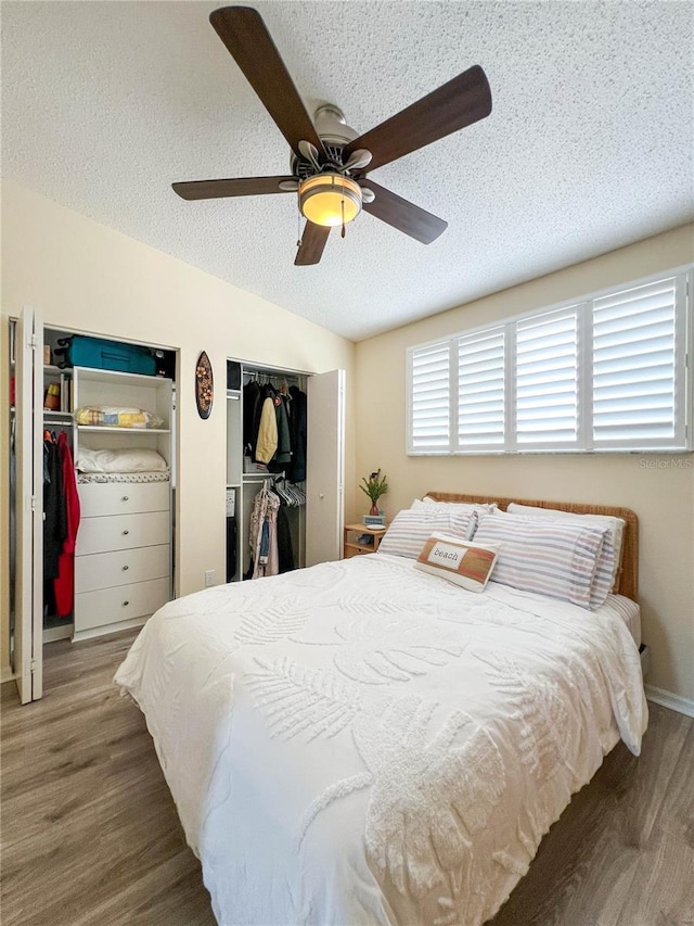 659 Garland Cir, Indian Rocks Beach, FL 33785 - bedroom featuring multiple closets, a textured ceiling, wood finished floors, a ceiling fan, and lofted ceiling