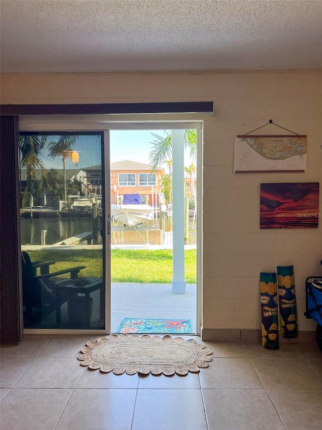 659 Garland Cir, Indian Rocks Beach, FL 33785 - doorway with a textured ceiling, tile patterned flooring, and a water view