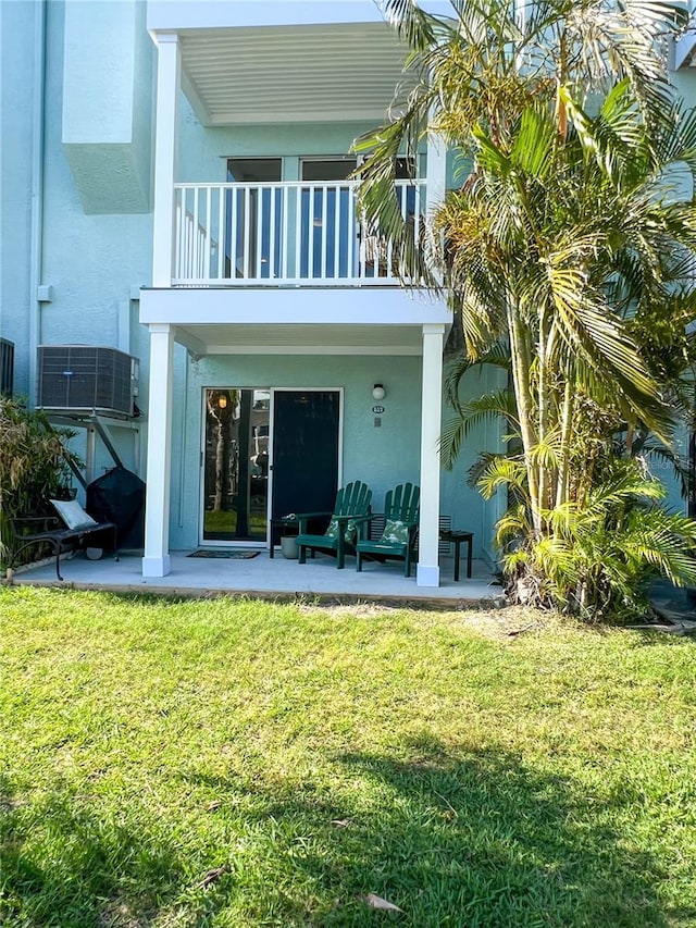 659 Garland Cir, Indian Rocks Beach, FL 33785 - back of house featuring a balcony, a patio, stucco siding, and a lawn