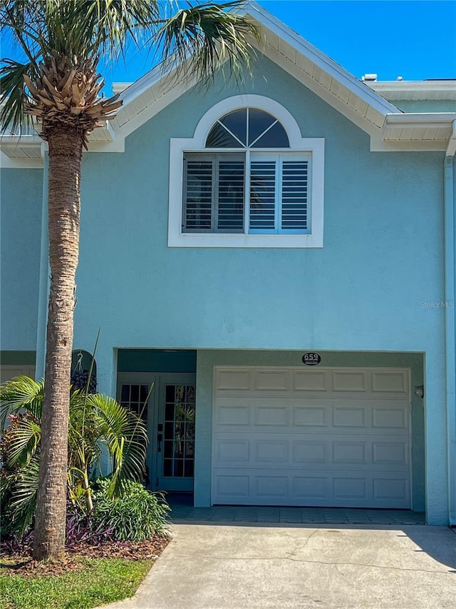 659 Garland Cir, Indian Rocks Beach, FL 33785 - view of property exterior featuring stucco siding, a garage, and concrete driveway