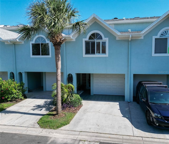 659 Garland Cir, Indian Rocks Beach, FL 33785 - view of front of house with a garage, concrete driveway, and stucco siding