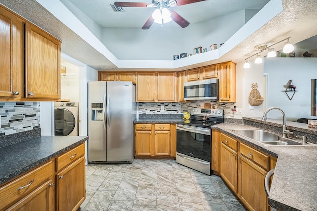 2507 Dewberry St, Valrico, FL 33596 - kitchen featuring appliances with stainless steel finishes, a sink, washer / clothes dryer, a ceiling fan, and backsplash