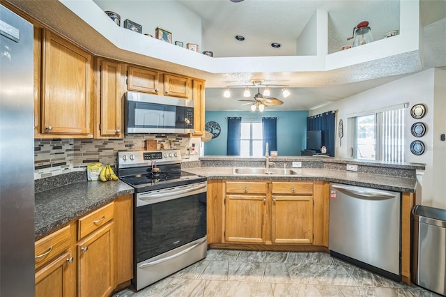 2507 Dewberry St, Valrico, FL 33596 - kitchen with stainless steel appliances, a sink, a ceiling fan, a peninsula, and brown cabinetry