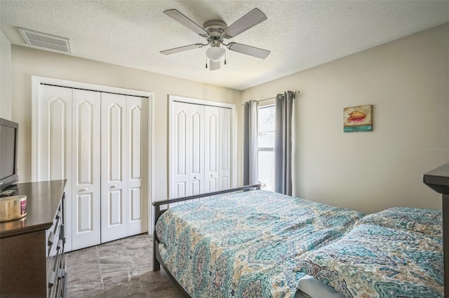 2507 Dewberry St, Valrico, FL 33596 - bedroom featuring multiple closets, a textured ceiling, and ceiling fan