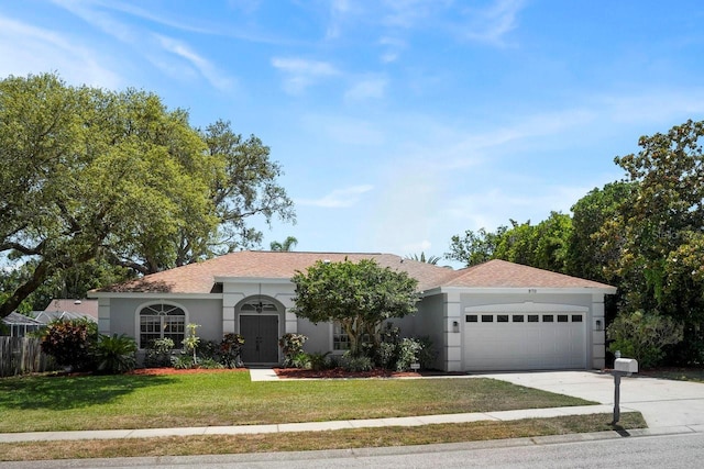 970 Ridgewood Ter, Tarpon Springs, FL 34689 - ranch-style home with stucco siding, a garage, a front yard, and concrete driveway
