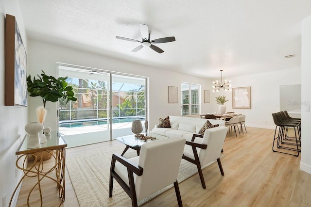 970 Ridgewood Ter, Tarpon Springs, FL 34689 - living room featuring ceiling fan, light wood-type flooring, baseboards, and a chandelier