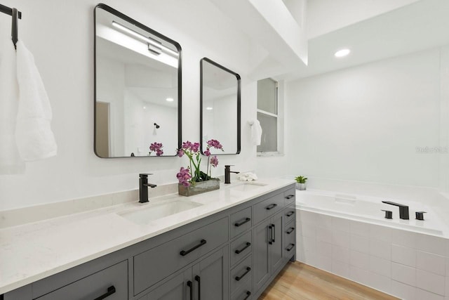 970 Ridgewood Ter, Tarpon Springs, FL 34689 - full bathroom with double vanity, a garden tub, and wood finished floors