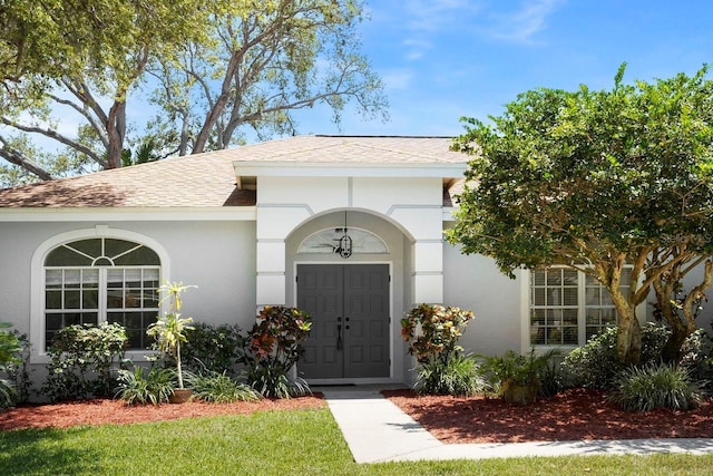 970 Ridgewood Ter, Tarpon Springs, FL 34689 - entrance to property with roof with shingles and stucco siding
