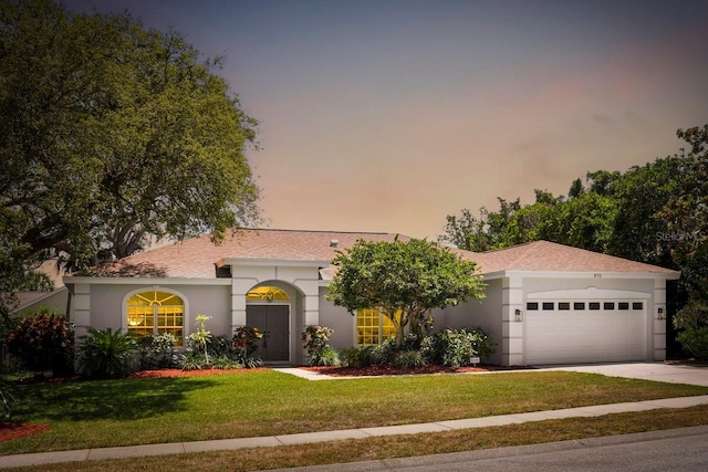 970 Ridgewood Ter, Tarpon Springs, FL 34689 - mediterranean / spanish-style home featuring a garage, a front yard, stucco siding, and concrete driveway
