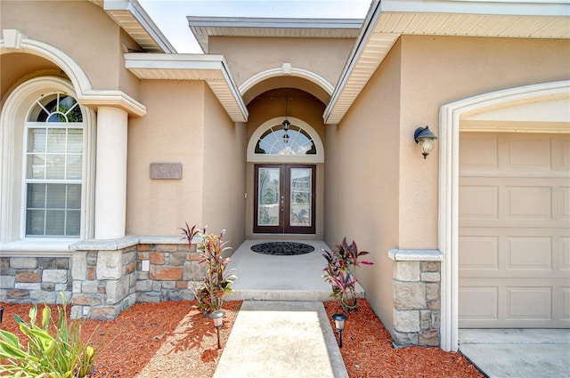 6519 Twin Bridges Dr, Zephyrhills, FL 33541 - view of exterior entry with stucco siding, stone siding, a garage, and french doors