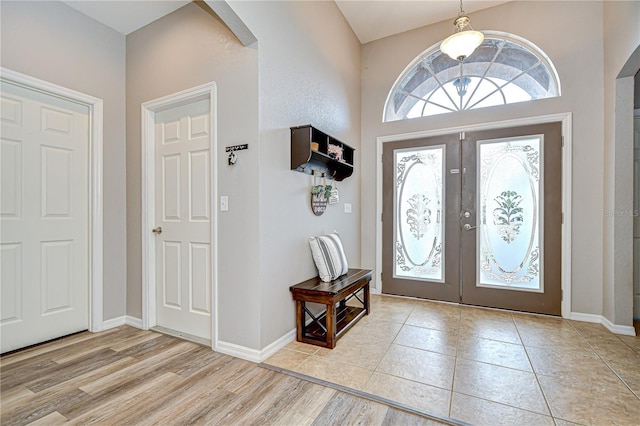 6519 Twin Bridges Dr, Zephyrhills, FL 33541 - foyer entrance featuring french doors, arched walkways, baseboards, and light wood finished floors