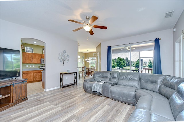 6519 Twin Bridges Dr, Zephyrhills, FL 33541 - living area featuring a ceiling fan, light wood-style flooring, and arched walkways