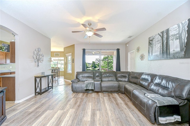 6519 Twin Bridges Dr, Zephyrhills, FL 33541 - living area with light wood-style floors, ceiling fan, and arched walkways