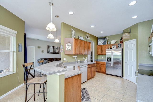 6519 Twin Bridges Dr, Zephyrhills, FL 33541 - kitchen featuring appliances with stainless steel finishes, a peninsula, a sink, light countertops, and a kitchen breakfast bar