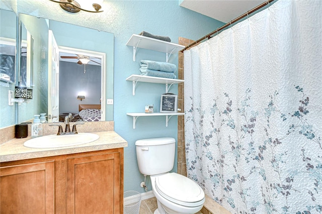 6519 Twin Bridges Dr, Zephyrhills, FL 33541 - ensuite bathroom featuring vanity, toilet, a ceiling fan, tile patterned flooring, and a shower with shower curtain