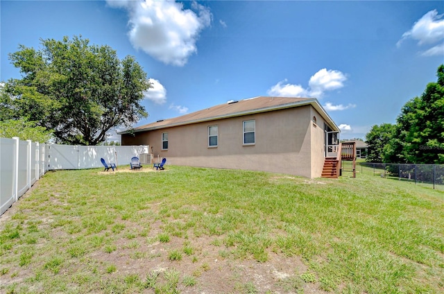 6519 Twin Bridges Dr, Zephyrhills, FL 33541 - rear view of property featuring stucco siding, stairway, a wooden deck, central AC unit, and an outdoor fire pit