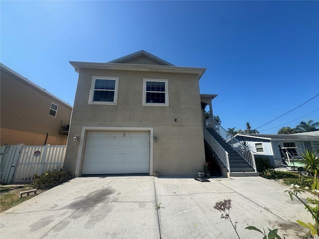 7330 New York Ave, Hudson, FL 34667 - view of front facade with stucco siding, an attached garage, driveway, and stairs