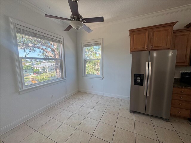 7330 New York Ave, Hudson, FL 34667 - kitchen featuring stainless steel fridge, light tile patterned floors, brown cabinets, crown molding, and a ceiling fan