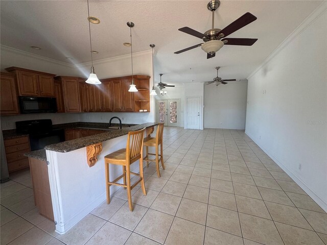 7330 New York Ave, Hudson, FL 34667 - kitchen featuring black appliances, ornamental molding, light tile patterned floors, a peninsula, and dark stone counters