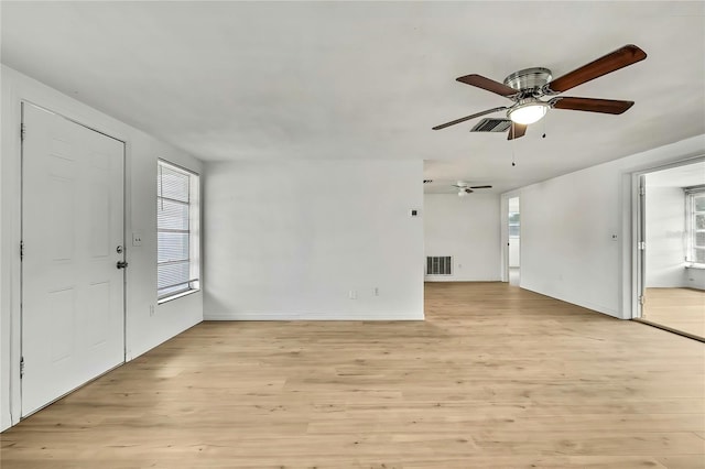 11130 White Oak Ln, Port Richey, FL 34668 - unfurnished living room with a ceiling fan, light wood-style floors, and baseboards
