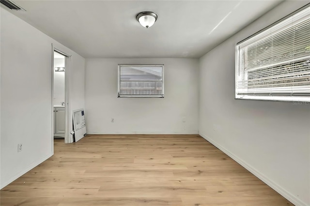 11130 White Oak Ln, Port Richey, FL 34668 - unfurnished bedroom with light wood finished floors and baseboards