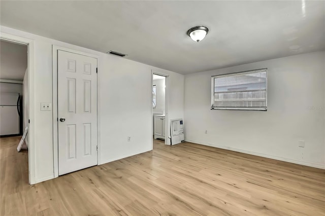 11130 White Oak Ln, Port Richey, FL 34668 - unfurnished bedroom featuring light wood-style flooring, baseboards, and ensuite bath