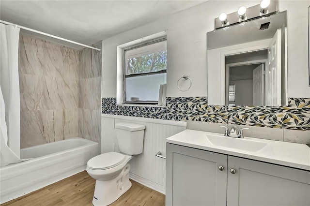 11130 White Oak Ln, Port Richey, FL 34668 - bathroom featuring shower / bath combo, toilet, vanity, wood finished floors, and wainscoting