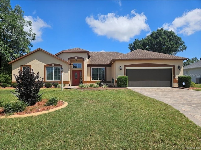 4755 N El Camino Dr, Beverly Hills, FL 34465 - view of front of home featuring stucco siding, a front yard, an attached garage, and decorative driveway