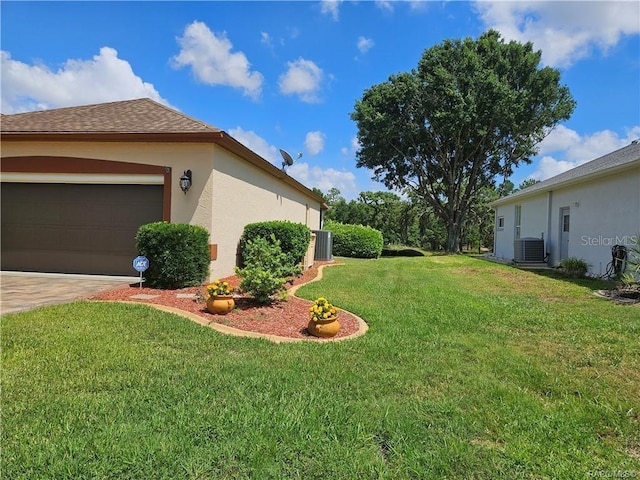 4755 N El Camino Dr, Beverly Hills, FL 34465 - view of green lawn featuring central AC unit, an attached garage, and driveway