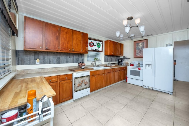 1683 Pine St, Largo, FL 33774 - kitchen with white appliances, light countertops, a sink, brown cabinetry, and a chandelier