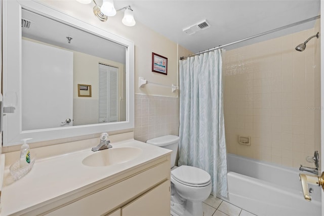 17710 Gulf Blvd Unit 304, Redington Shores, FL 33708 - bathroom with vanity, tile patterned floors, shower / bathtub combination with curtain, tile walls, and a wainscoted wall