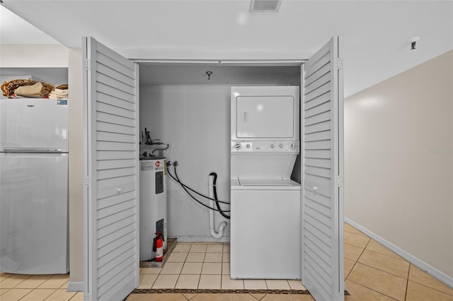 17710 Gulf Blvd Unit 304, Redington Shores, FL 33708 - laundry area with estacked washer and dryer, light tile patterned floors, and water heater