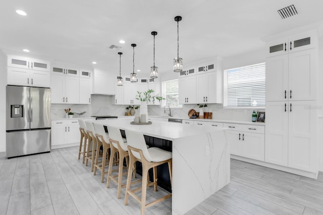 3616 W Anderson Ave, Tampa, FL 33611 - kitchen with stainless steel fridge, a center island, decorative backsplash, a sink, and decorative light fixtures
