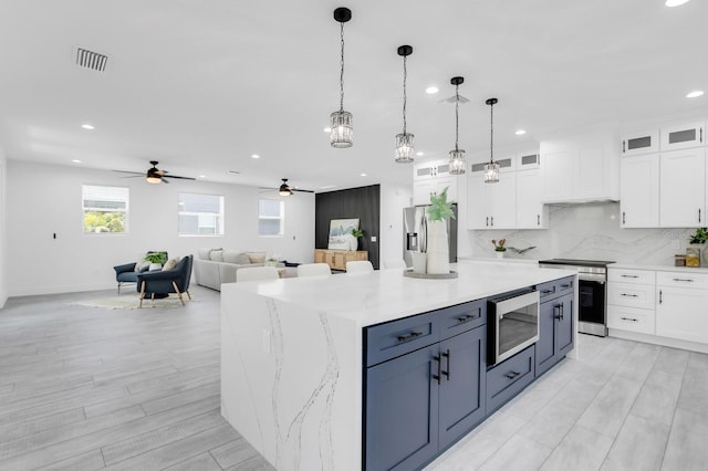 3616 W Anderson Ave, Tampa, FL 33611 - kitchen with appliances with stainless steel finishes, white cabinetry, recessed lighting, a ceiling fan, and decorative light fixtures