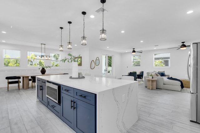 3616 W Anderson Ave, Tampa, FL 33611 - kitchen with stainless steel appliances, ceiling fan, recessed lighting, hanging light fixtures, and a center island