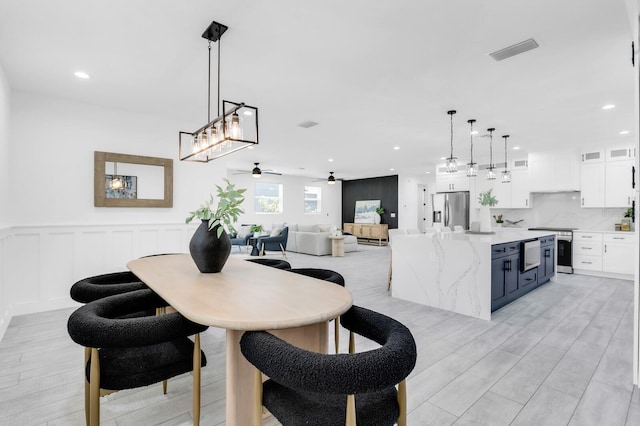 3616 W Anderson Ave, Tampa, FL 33611 - dining space with ceiling fan, light wood finished floors, recessed lighting, and wainscoting