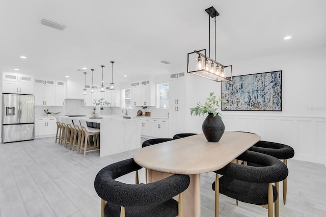 3616 W Anderson Ave, Tampa, FL 33611 - dining room featuring a chandelier, recessed lighting, a wainscoted wall, and light wood-style floors
