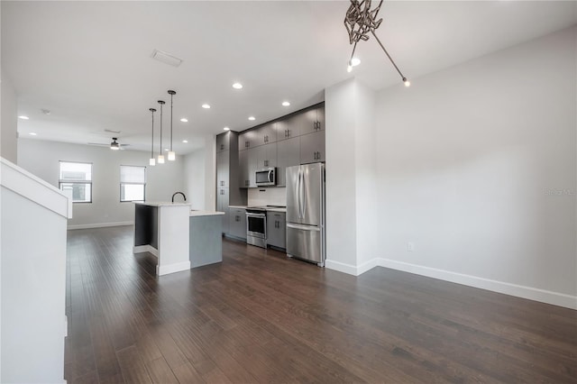 1330 W Gray St Unit 1, Tampa, FL 33606 - kitchen featuring stainless steel appliances, open floor plan, light countertops, gray cabinetry, and a center island with sink
