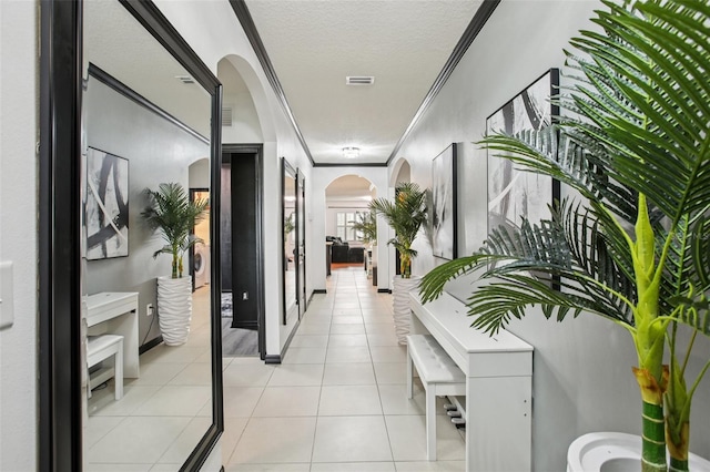 10233 Opaline Sky Pl, Riverview, FL 33578 - hall featuring arched walkways, crown molding, a textured ceiling, and light tile patterned flooring