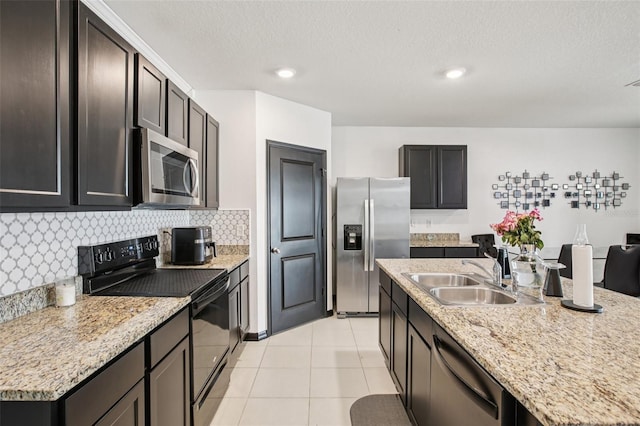 10233 Opaline Sky Pl, Riverview, FL 33578 - kitchen with stainless steel appliances, a sink, tasteful backsplash, light tile patterned flooring, and a kitchen island with sink