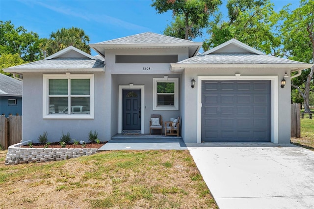 8608 N Arden Ave, Tampa, FL 33604 - view of front of house featuring an attached garage, driveway, stucco siding, and a shingled roof