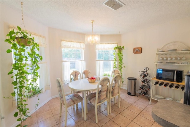 2826 Martha Ln, Land O Lakes, FL 34639 - dining room with a chandelier, light tile patterned floors, a textured ceiling, and baseboards