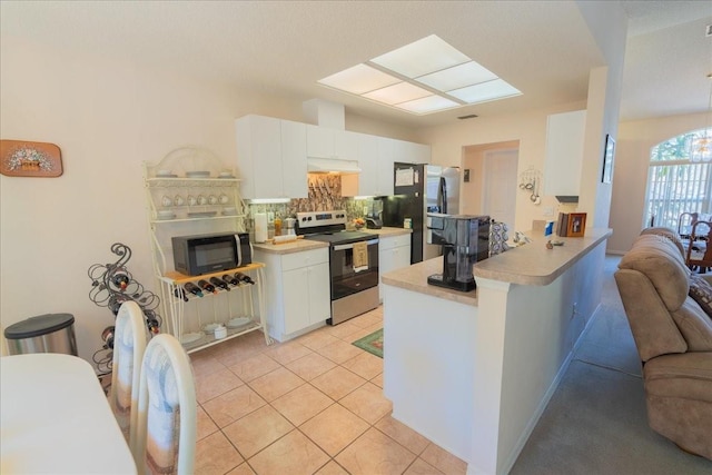 2826 Martha Ln, Land O Lakes, FL 34639 - kitchen featuring appliances with stainless steel finishes, light countertops, under cabinet range hood, tasteful backsplash, and a peninsula